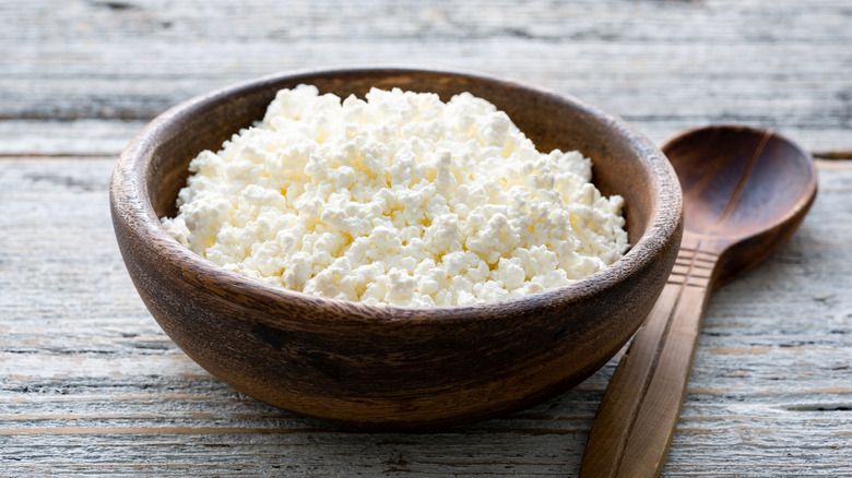 Ricotta cheese, cottage cheese farmers cheese, curd or tvorog in a wooden bowl